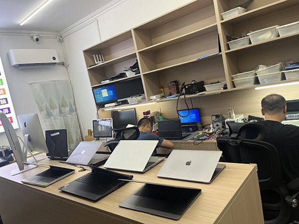 速帮维修工程师在门店工作台前拆机检修笔记本电脑