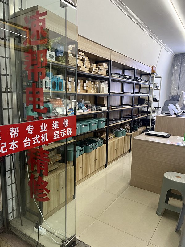 门店维修区货架整齐码放配件与待售笔记本
