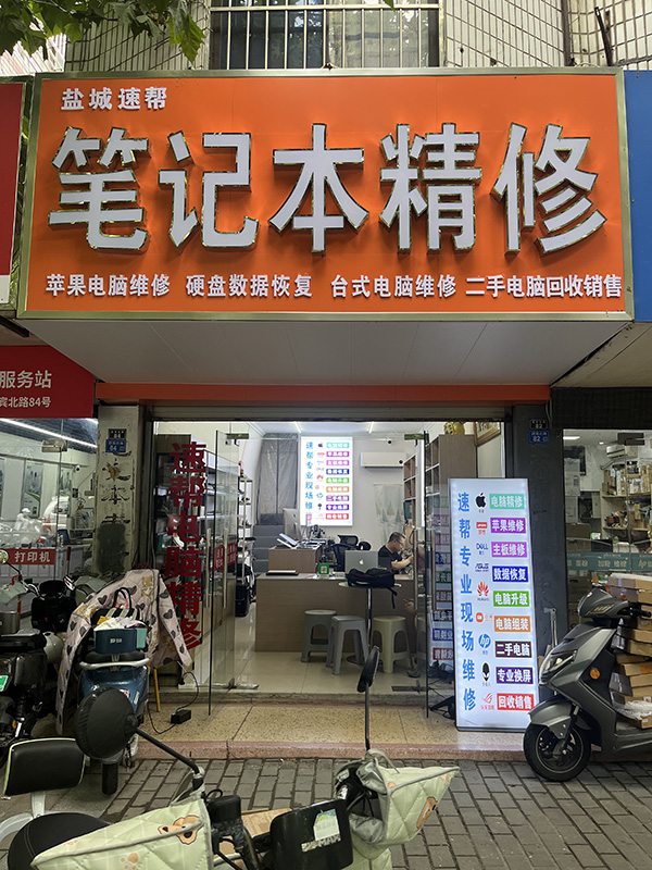 速帮笔记本维修服务中心沿街门店实景，橙色门头标注笔记本精修